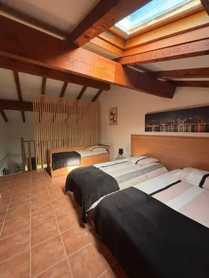 two beds in a large room with wooden ceilings at Appartement bord de mer in San-Nicolao
