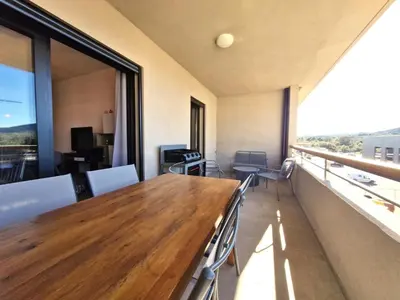 a room with a table and chairs and a large window at Résidence Poggiarelli in Sainte-Lucie de Porto-Vecchio