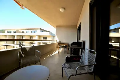 a balcony with chairs and tables on a building at Résidence Poggiarelli in Sainte-Lucie de Porto-Vecchio
