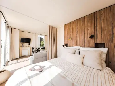 a bedroom with a large bed with a wooden wall at Bungalow cosy avec terrasse - 2 pers. - API-1-52-1974 in Linguizzetta