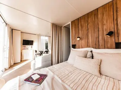 a bedroom with a large bed with a wooden wall at Bungalow cosy avec terrasse - 2 pers. - API-1-52-1974 in Linguizzetta