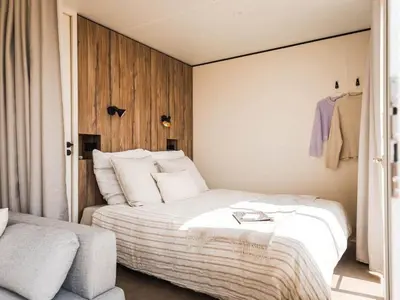 a bedroom with a large bed and a chair at Bungalow cosy avec terrasse - 2 pers. - API-1-52-1974 in Linguizzetta