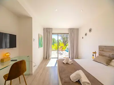 a bedroom with two beds and a large window at Villa Dicianove in Porto-Vecchio