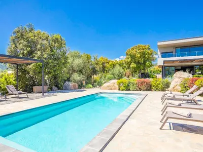 a bedroom with two beds and a large window at Villa Dicianove in Porto-Vecchio