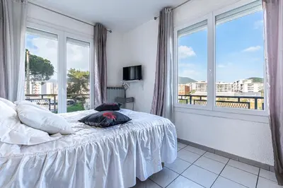 a bedroom with a bed and a large window at Le Ricci - Climatisé plages à 2 km in Ajaccio