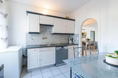 a kitchen with white cabinets and a counter top at Le Ricci - Climatisé plages à 2 km in Ajaccio
