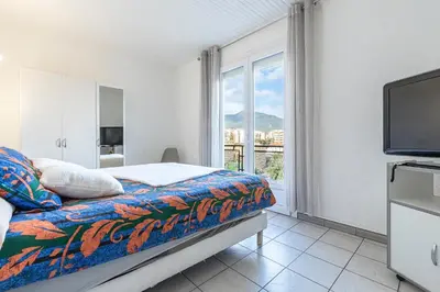 a bedroom with a bed and a tv and a window at Le Ricci - Climatisé plages à 2 km in Ajaccio