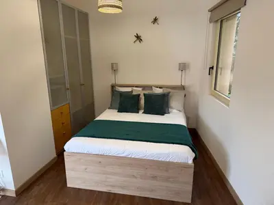 a small bedroom with a bed with green pillows at Grand Studio hyper centre PORTO-VECCHIO in Porto-Vecchio