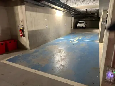 a parking garage with a blue floor with a fire hydrant at Logement PMR 2-4 personnes - piscine - clim - 100m de la plage in Sari Solenzara