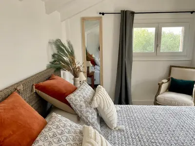 a bedroom with a bed with pillows and a mirror at Villa bord de plage à pied proche Pinarello in Sainte-Lucie de Porto-Vecchio