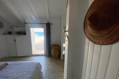 a bedroom with a bed and a door leading to a doorway at Villa bord de plage à pied proche Pinarello in Sainte-Lucie de Porto-Vecchio