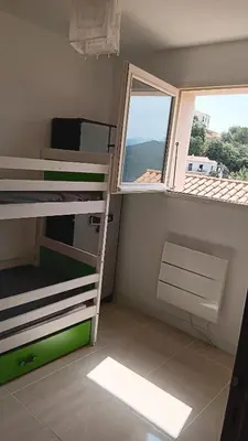 a small room with two bunk beds and a window at Maison pour 6 avec piscine in Lama
