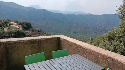 a bench sitting on a wall with a view of mountains at Maison pour 6 avec piscine in Lama