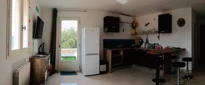 a kitchen with a white refrigerator and a table at Maison pour 6 avec piscine in Lama