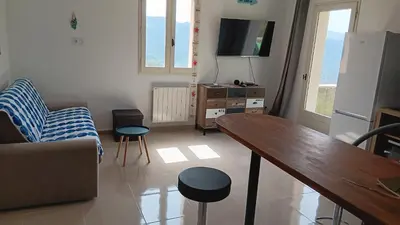a living room with a couch and a table and a tv at Maison pour 6 avec piscine in Lama