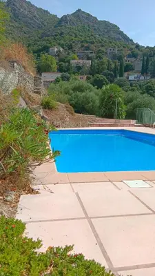 a blue swimming pool with a mountain in the background at Maison pour 6 avec piscine in Lama