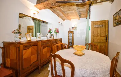 a dining room with a table and a mirror at Maison Typique De Village in Lopigna