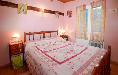 a bedroom with a bed with a quilt on it at Maison Typique De Village in Lopigna