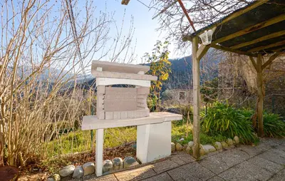 a wooden bird house sitting in a garden at Maison Typique De Village in Lopigna