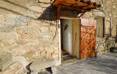an entrance to a stone building with a wooden door at Maison Typique De Village in Lopigna