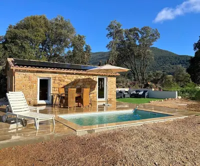 a bedroom with a bed and a table in a room at Bergerie du Riccio avec piscine privée in Cauro