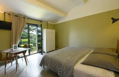 a bedroom with a bed and a table and a window at Appart'hotel Fior Di Ribba in Sartène