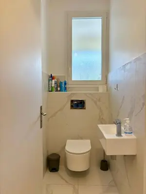 a bathroom with a toilet and a sink and a window at Ajaccio centre vue mer in Ajaccio