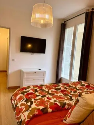 a bedroom with a bed and a tv on the wall at Ajaccio centre vue mer in Ajaccio