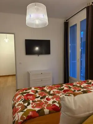 a bedroom with a bed and a television on the wall at Ajaccio centre vue mer in Ajaccio