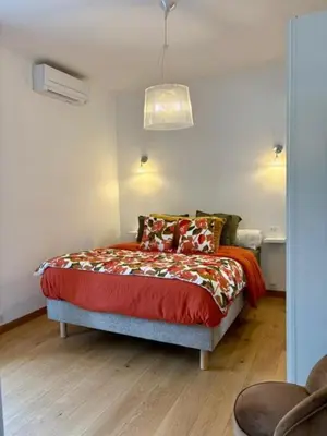 a bedroom with a bed with a red comforter at Ajaccio centre vue mer in Ajaccio