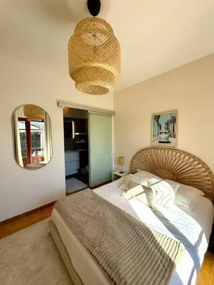 a bedroom with a large bed and a chandelier at Maison 4 chambres vue mer Jardin et plage à 1 min in Olmeto
