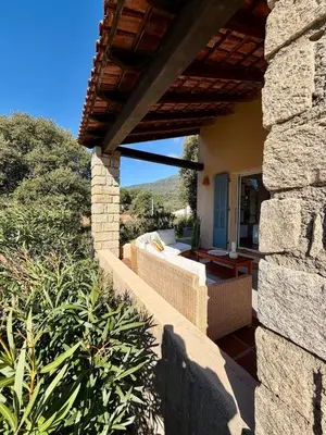 a patio of a house with a couch and a table at Maison 4 chambres vue mer Jardin et plage à 1 min in Olmeto