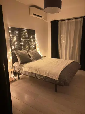 a bedroom with a bed with lights on it at Ajaccienne in Ajaccio