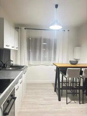 a kitchen with a table and chairs and a window at Ajaccienne in Ajaccio