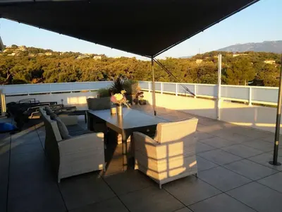 a patio with a table and chairs on a roof at Apartment La Boétie by Interhome in Porto-Vecchio