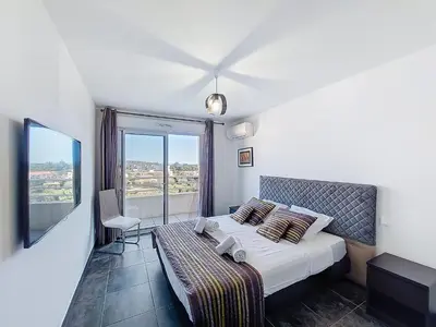 a hotel room with a bed and a large window at Apartment La Boétie by Interhome in Porto-Vecchio