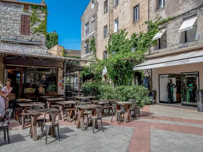 a street with tables and chairs in front of a store at Holiday Home Babo by Interhome in Porto-Vecchio