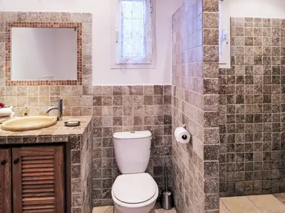 a bathroom with a toilet and a sink at Holiday Home Babo by Interhome in Porto-Vecchio