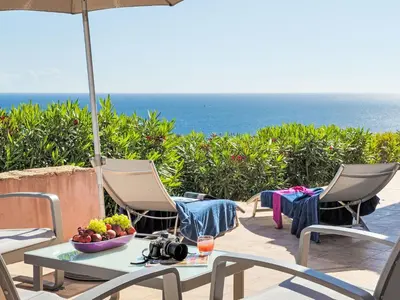 a table with a bowl of fruit and an umbrella at Holiday Home Quenza by Interhome in Porto-Vecchio