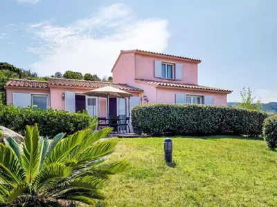 a pink house with a lawn in front of it at Holiday Home Quenza by Interhome in Porto-Vecchio