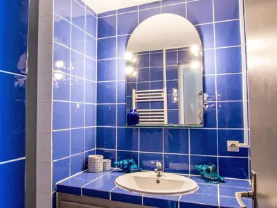 a blue tiled bathroom with a sink and a mirror at Holiday Home Haut Casa Blue by Interhome in Sainte-Lucie de Porto-Vecchio