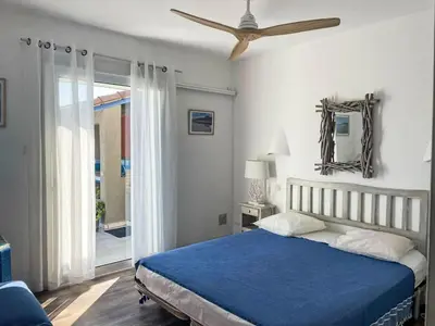 a bedroom with a blue bed and a ceiling fan at Holiday Home Haut Casa Blue by Interhome in Sainte-Lucie de Porto-Vecchio