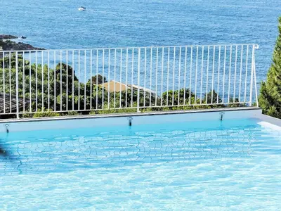 a swimming pool with the ocean in the background at Holiday Home Anto by Interhome in Porto-Vecchio