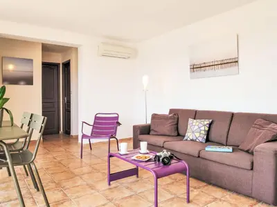 a living room with a couch and a table and chairs at Holiday Home Anto by Interhome in Porto-Vecchio