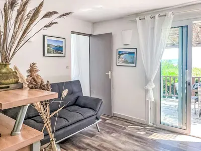 a living room with a couch and a glass door at Apartment Bas Casa Blue by Interhome in Sainte-Lucie de Porto-Vecchio