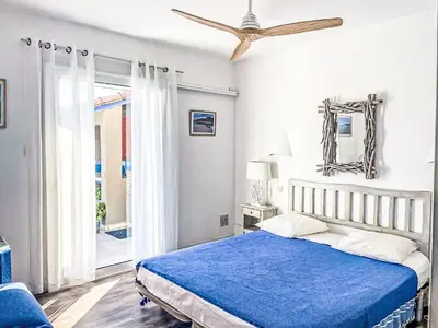 a bedroom with a blue bed and a ceiling fan at Holiday Home Casa Blue by Interhome in Sainte-Lucie de Porto-Vecchio