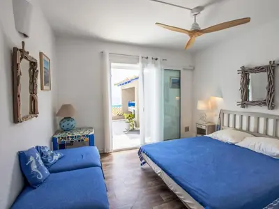 a bedroom with a blue bed and a couch at Holiday Home Casa Blue by Interhome in Sainte-Lucie de Porto-Vecchio
