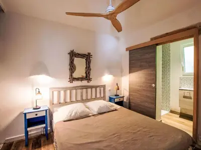 a bedroom with a bed and two night tables and a mirror at Holiday Home Casa Blue by Interhome in Sainte-Lucie de Porto-Vecchio