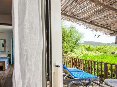 a room with a balcony with a chair and a bed at Holiday Home Casa Blue by Interhome in Sainte-Lucie de Porto-Vecchio