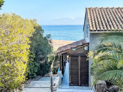 a house with a porch with the ocean in the background at Holiday Home Casa Blue by Interhome in Sainte-Lucie de Porto-Vecchio